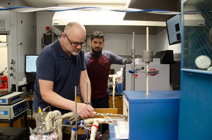 Ed Sabolsky (left), a WVU professor, works with materials science doctoral candidate Saad Waseem (right) to prepare a solid oxide electrolysis cell test.